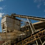 View of rusty machinery and structures at an industrial plant in Córdoba under a clear blue sky.